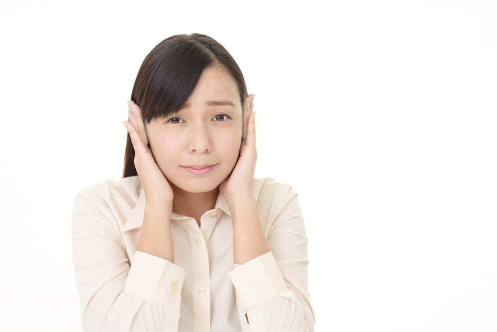 young woman holding her hands over her ears