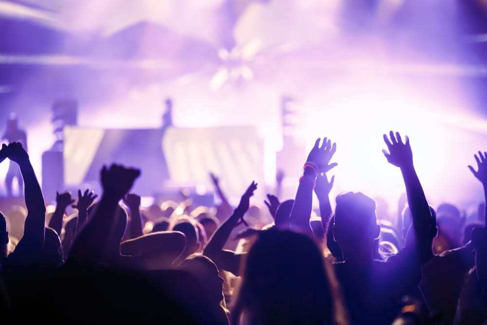 backlit cheering crowd at loud concert