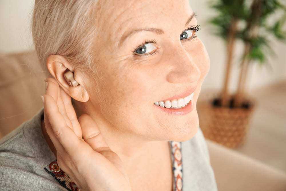 Close-up of woman with hearing aid smiling